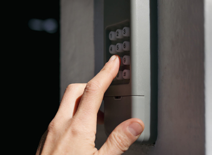 Hand typing in garage door opener keypad