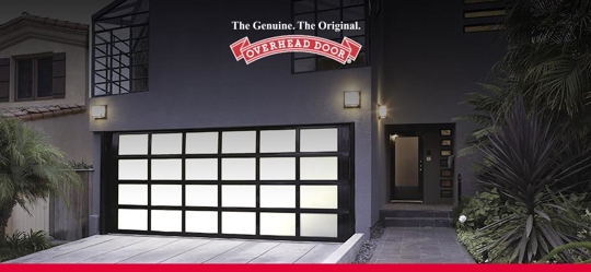 A modern home features an Overhead Door garage door with a black frame and frosted glass panes.